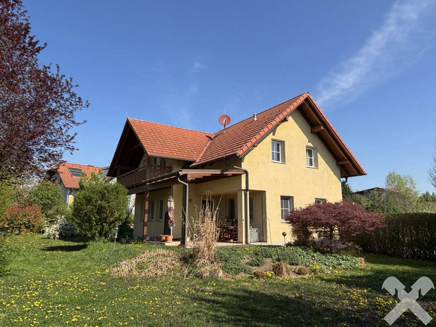 Großzügiger Gartenbereich mit dem Wohnhaus im Hintergrund und weitem Blick in die Natur.