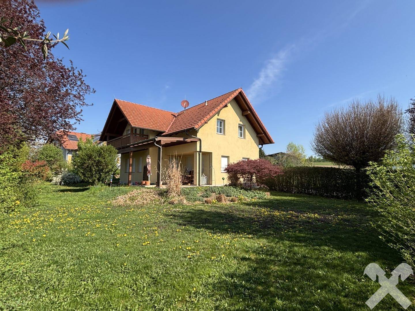 Weitläufiger grüner Garten mit Blick auf das Wohnhaus und die umliegende Landschaft.