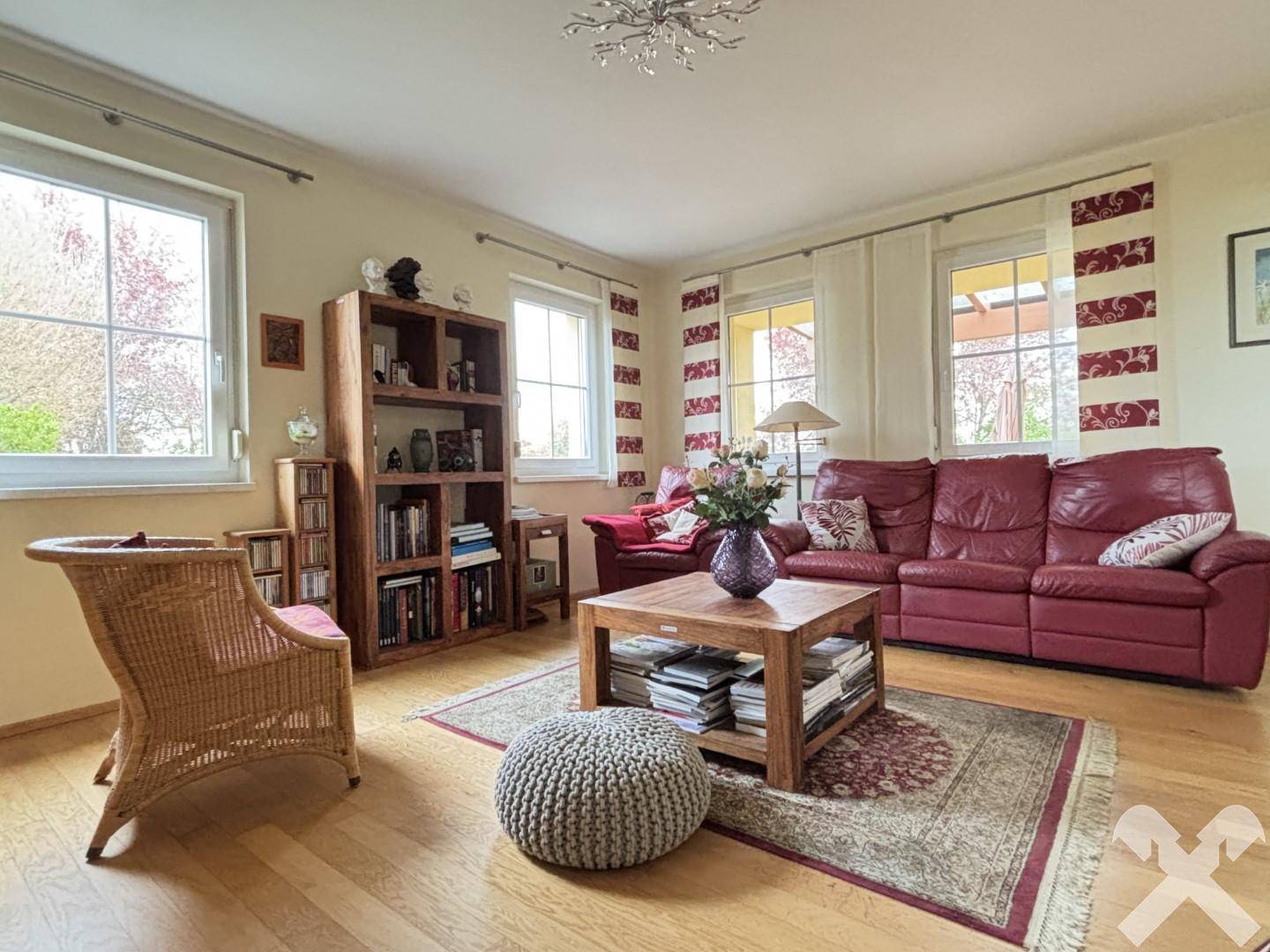 Gemütliches Wohnzimmer mit Holzboden, bequemen Sofas und Blick in den Garten.