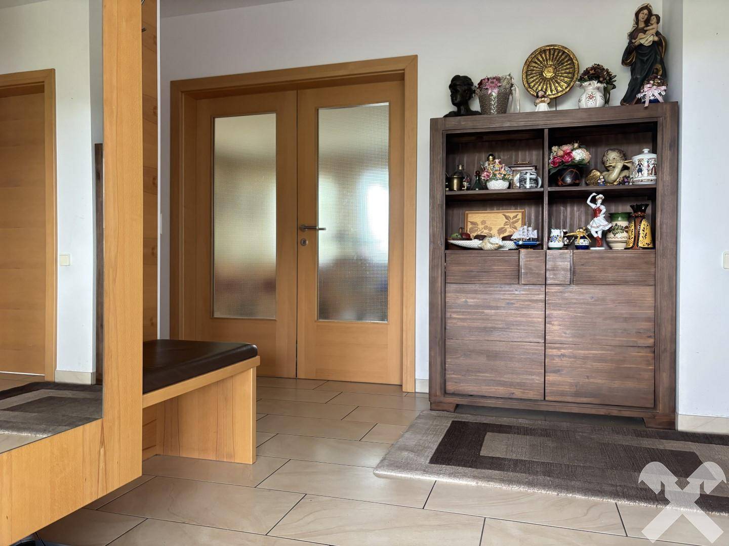 Geräumiger Flur mit Fliesenboden, Holzmöbeln und Zugang zu weiteren Räumen.
