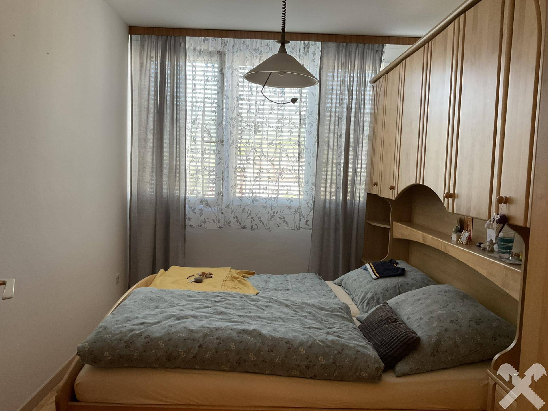 Schlafzimmer mit Doppelbett und Einbauschränken, bietet ausreichend Stauraum und Tageslicht.