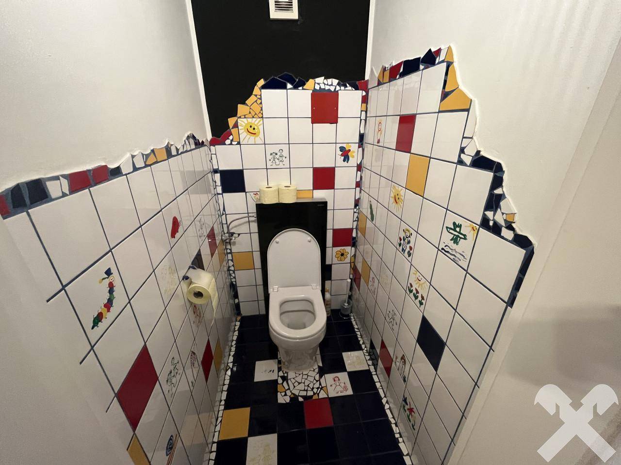 Originelles Gäste-WC mit farbenfrohen Fliesen und kreativer Gestaltung.