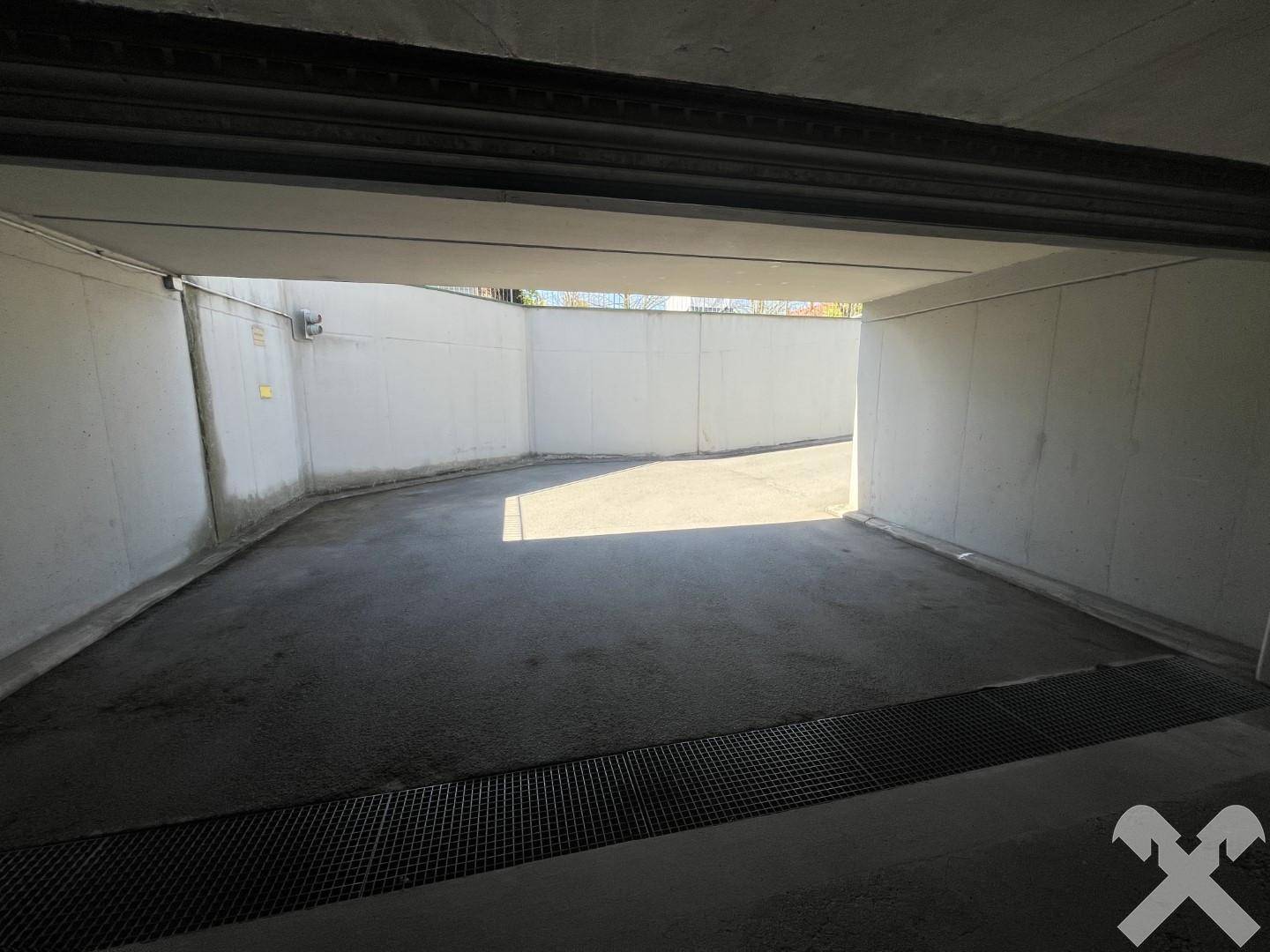 Innenansicht einer hellen Tiefgarage mit ausreichend Platz für Fahrzeuge.