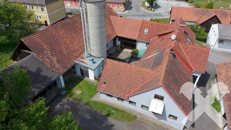 Draufsicht auf den Gebäudekomplex mit Innenhof, roten Ziegeldächern und einem markanten Silo.