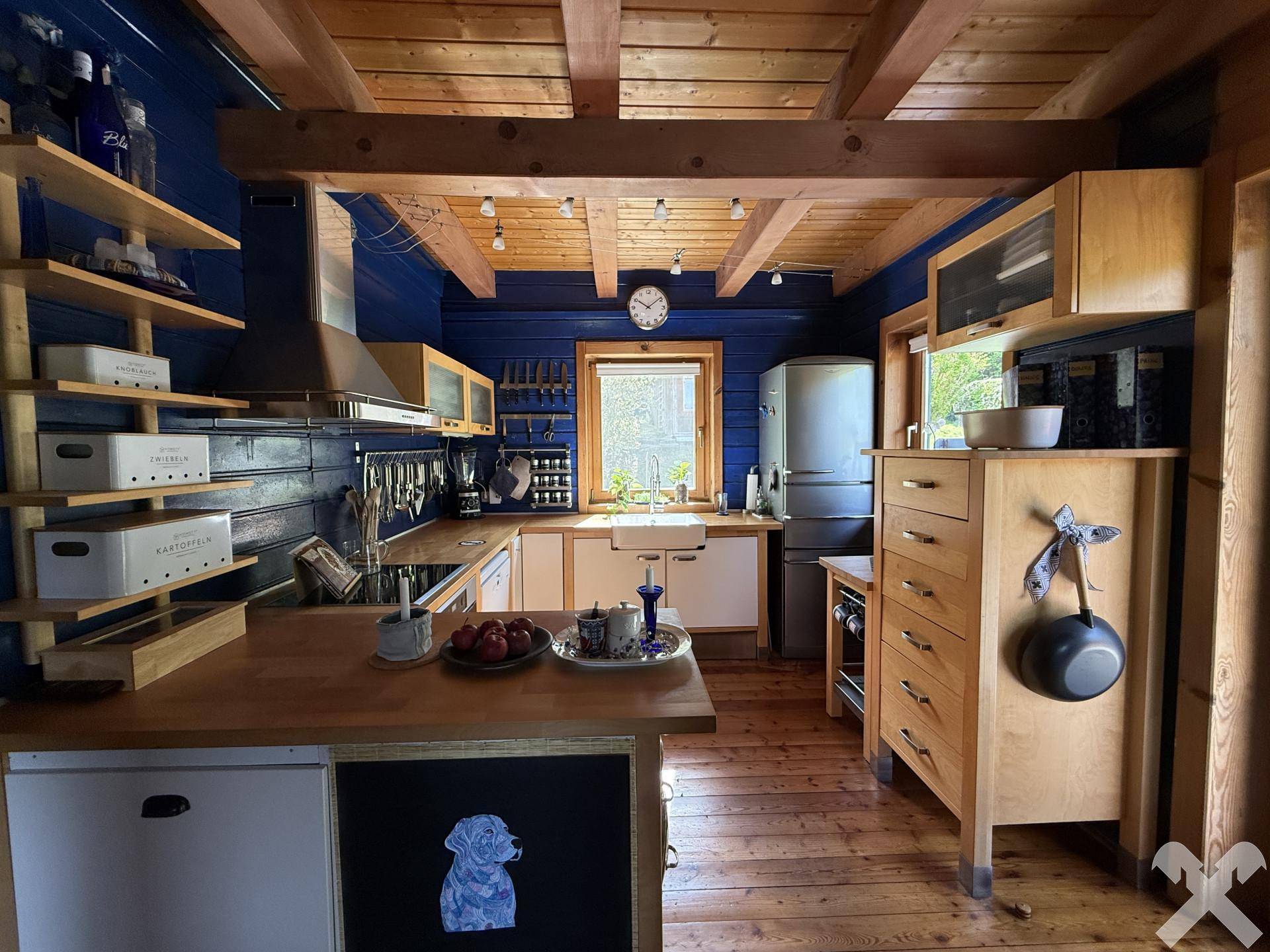 Rustikale Küche mit blauen Holzwänden, Holzbalkendecke und Holzfußboden.