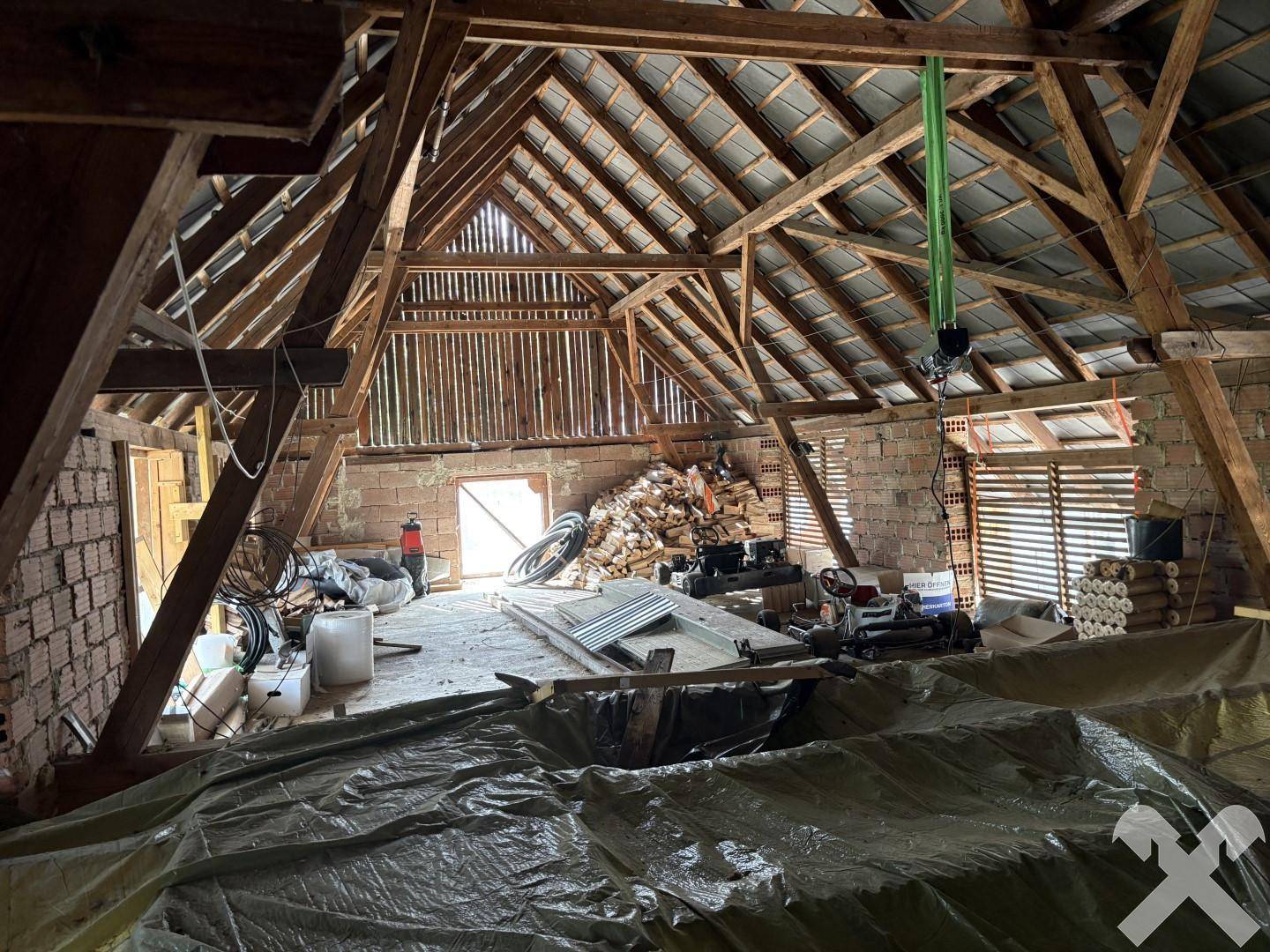 Geräumiger Dachboden mit sichtbarer Holzkonstruktion und Lagerflächen, bereit für Ausbau.