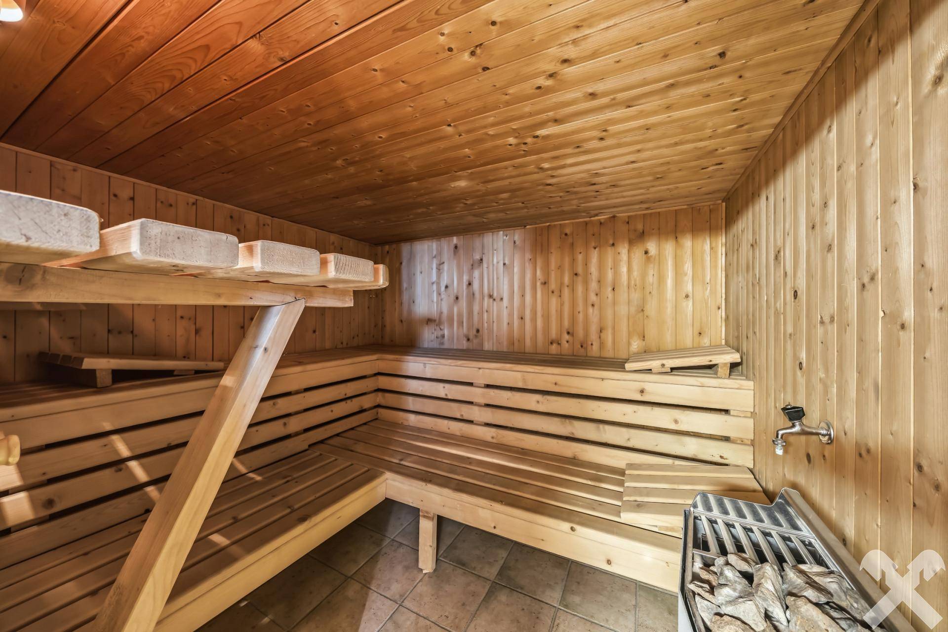 Private Sauna mit Holzverkleidung und mehreren Sitzebenen für Entspannung.