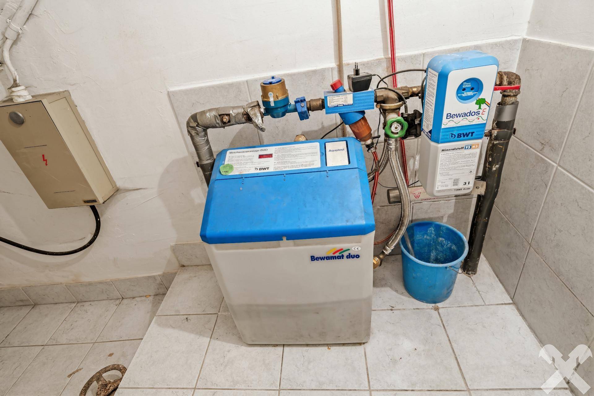 Technikraum mit Wasseraufbereitungsanlage und Fliesenboden.