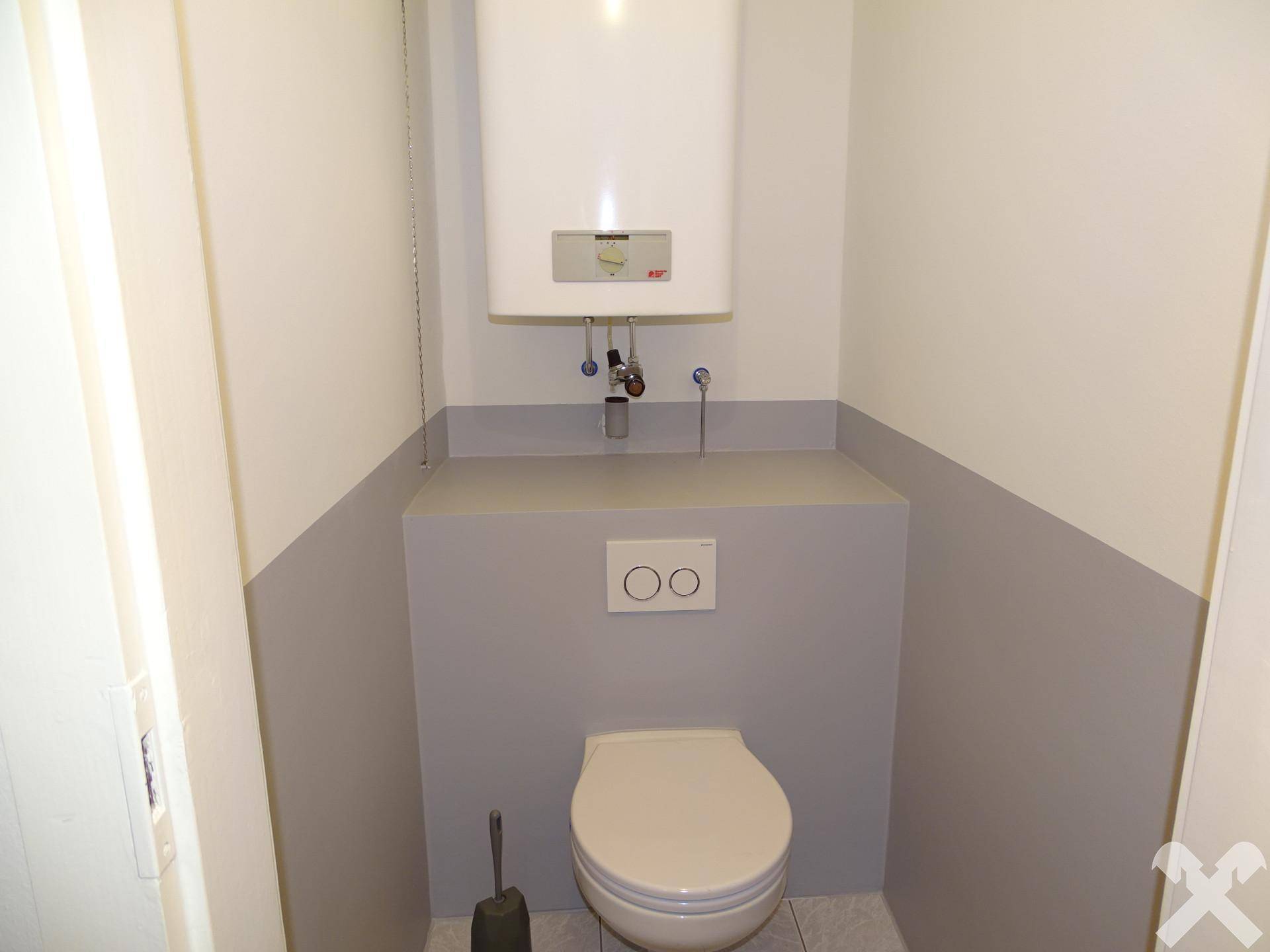 Separates WC mit wandhängender Toilette und Warmwasserboiler.