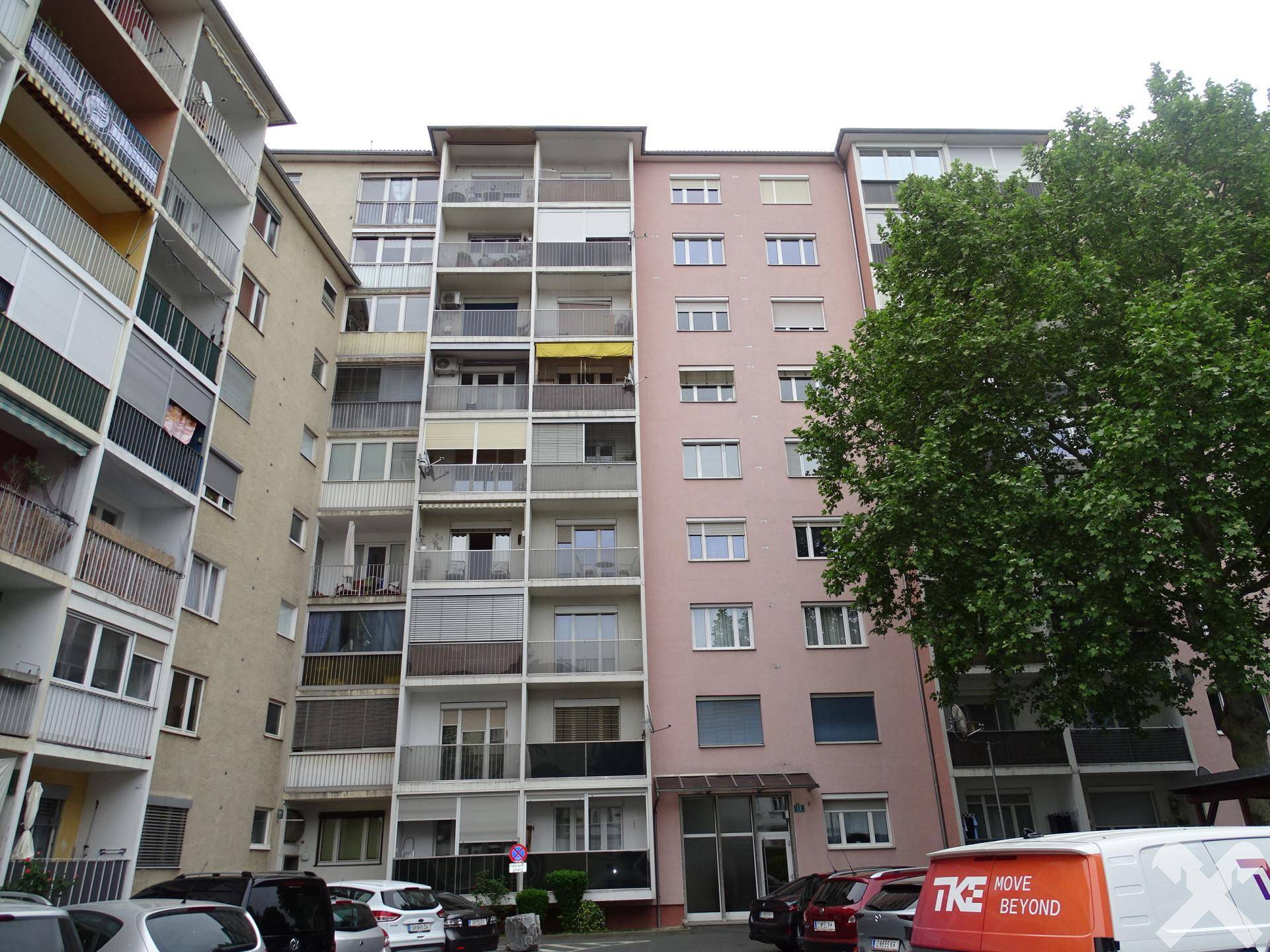 Fassade eines Mehrfamilienhauses mit vielen Balkonen und Fenstern.