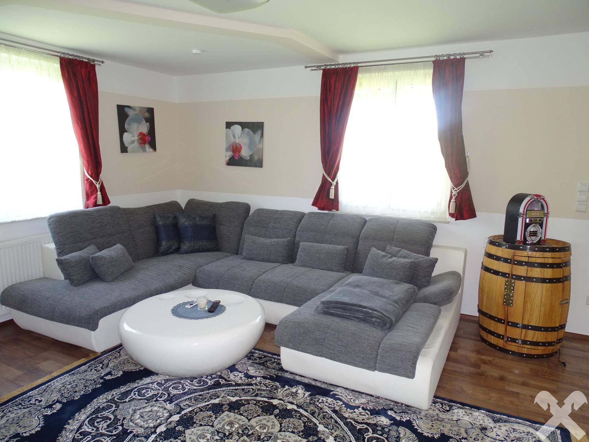 Helles Wohnzimmer mit bequemem Ecksofa, Couchtisch und dekorativem Teppich.