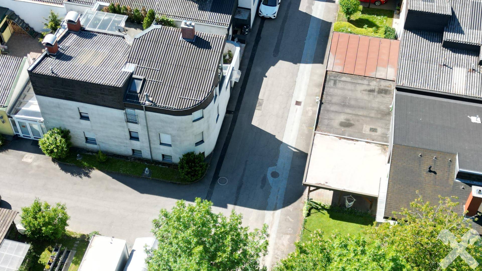 Draufsicht auf das Gebäude und die angrenzende Straße mit weiteren Häusern in der Umgebung.