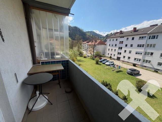 Balkon mit kleinem Tisch und Stühlen, bietet einen weiten Blick über die Umgebung.