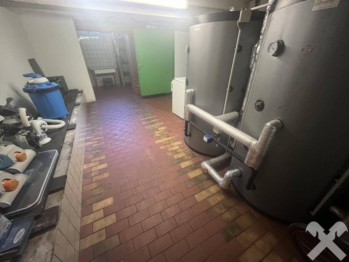 Geräumiger Kellerraum mit großen Wassertanks und robustem Fliesenboden, vielseitig nutzbar.