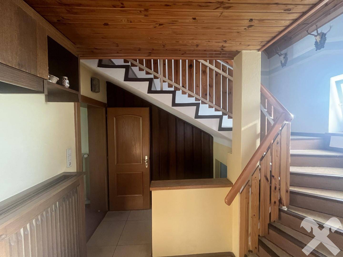 Holztreppe mit Geländer, die zu den oberen Stockwerken führt und traditionellen Charme versprüht.