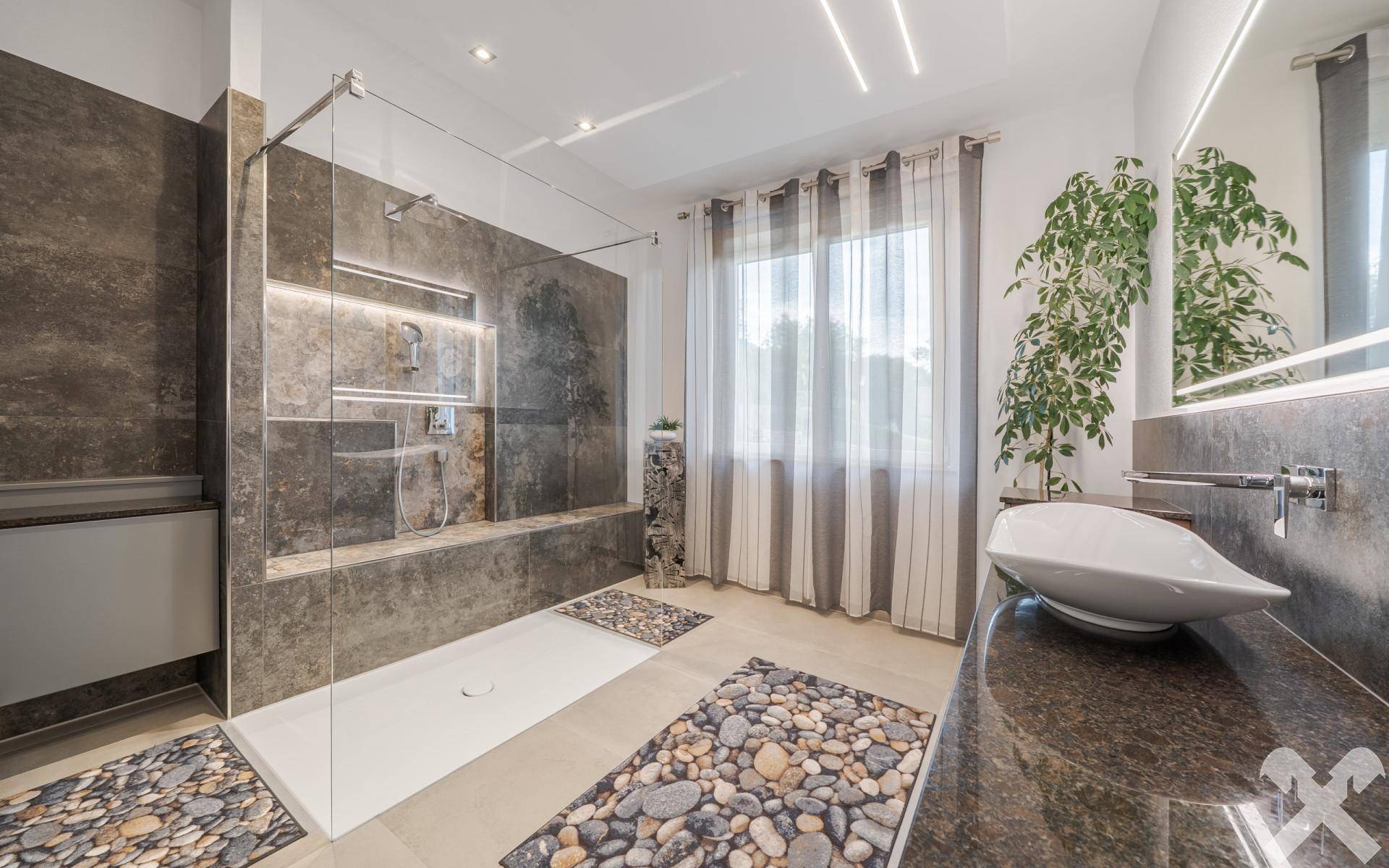Modernes Badezimmer mit großer begehbarer Dusche, stilvollen Fliesen und einem eleganten Waschbecken.