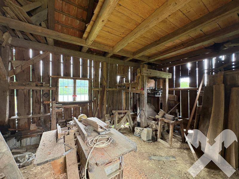 Rustikale Werkstatt oder Lagerraum in einer Scheune mit Holzwänden und verschiedenen Werkzeugen.