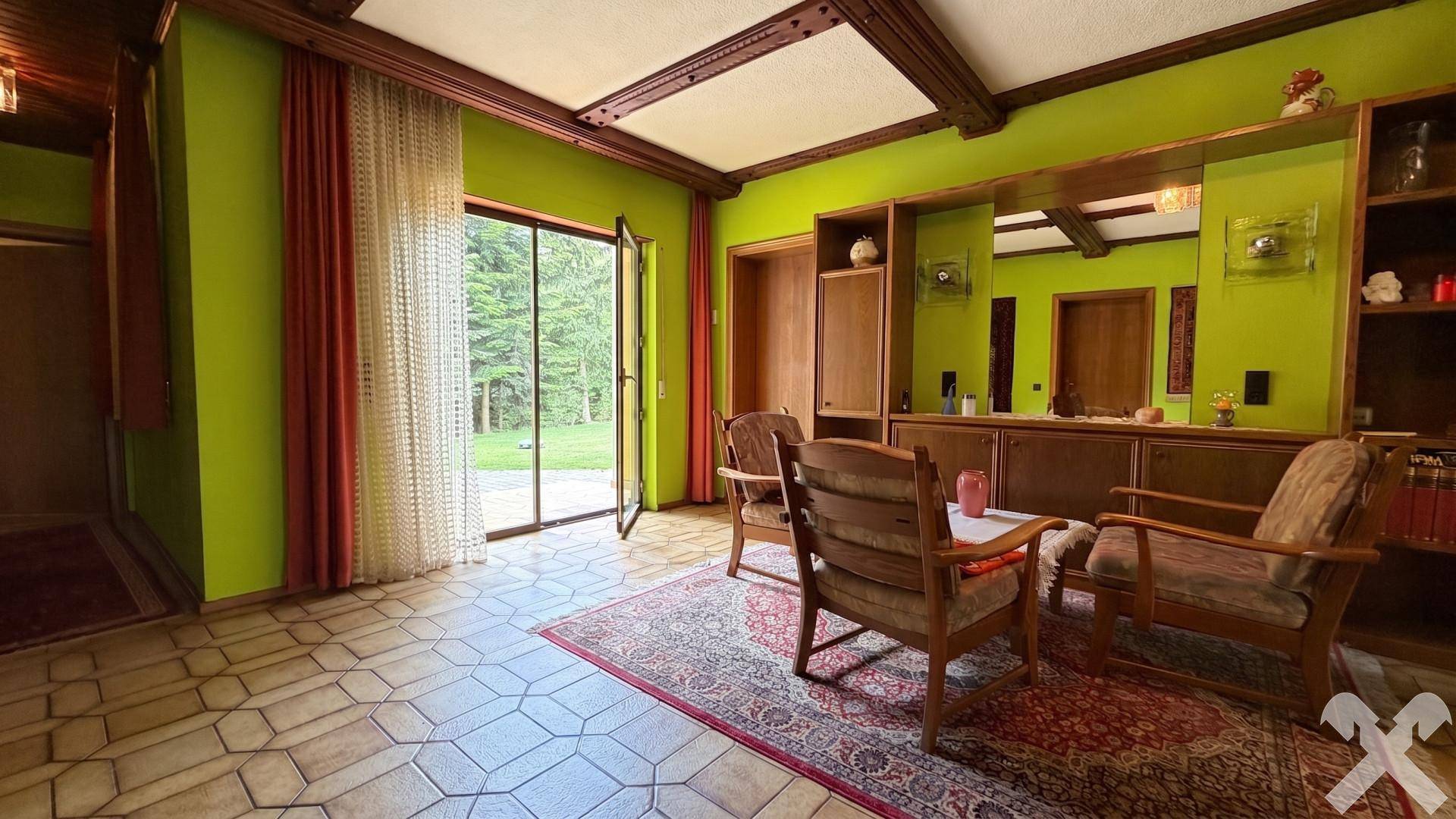 Heller Flur mit Zugang zum Garten, grünen Wänden und rustikalen Holzbalken an der Decke.