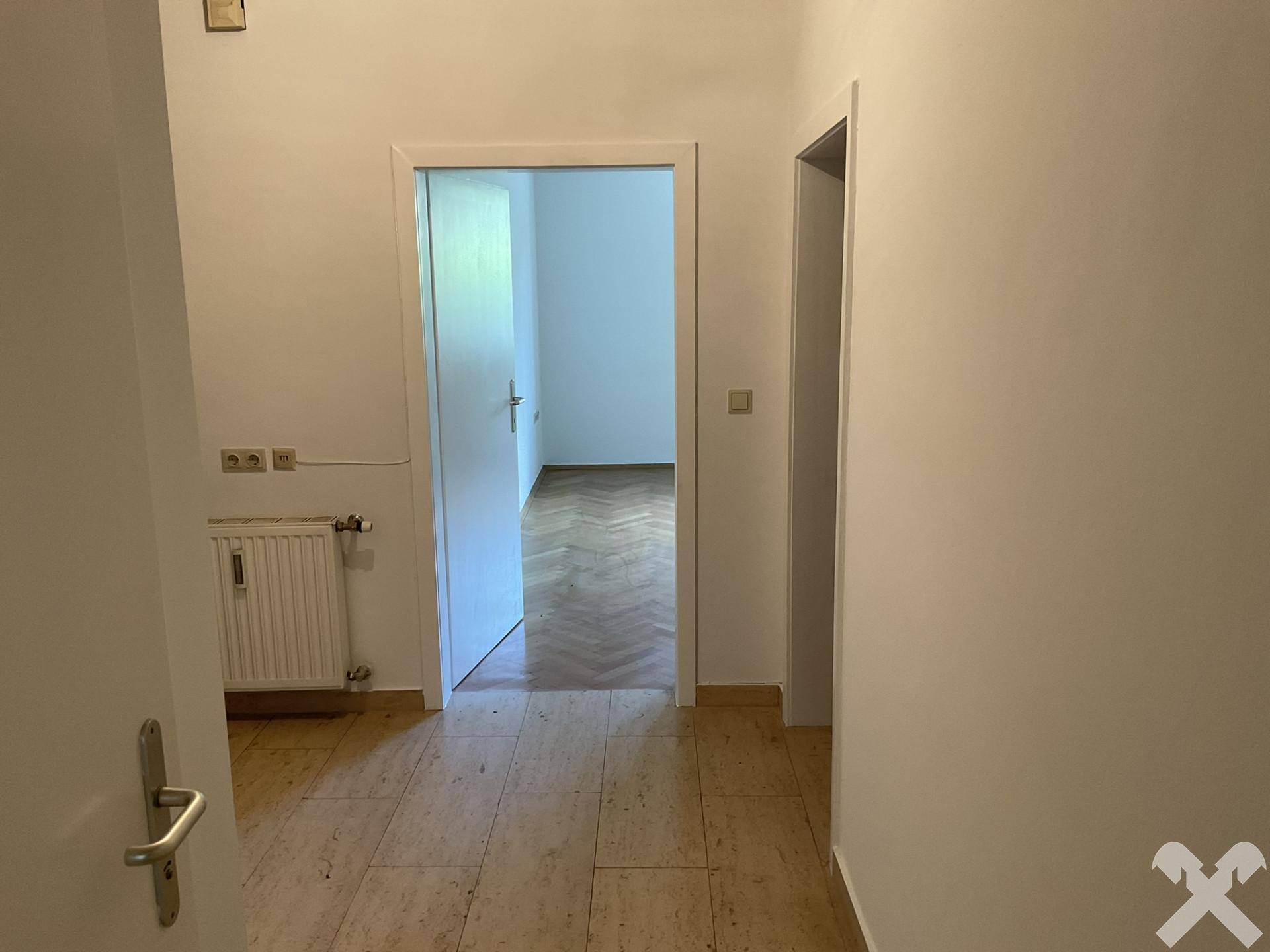 Heller Flur mit Fliesenboden und Zugang zu weiteren Zimmern.