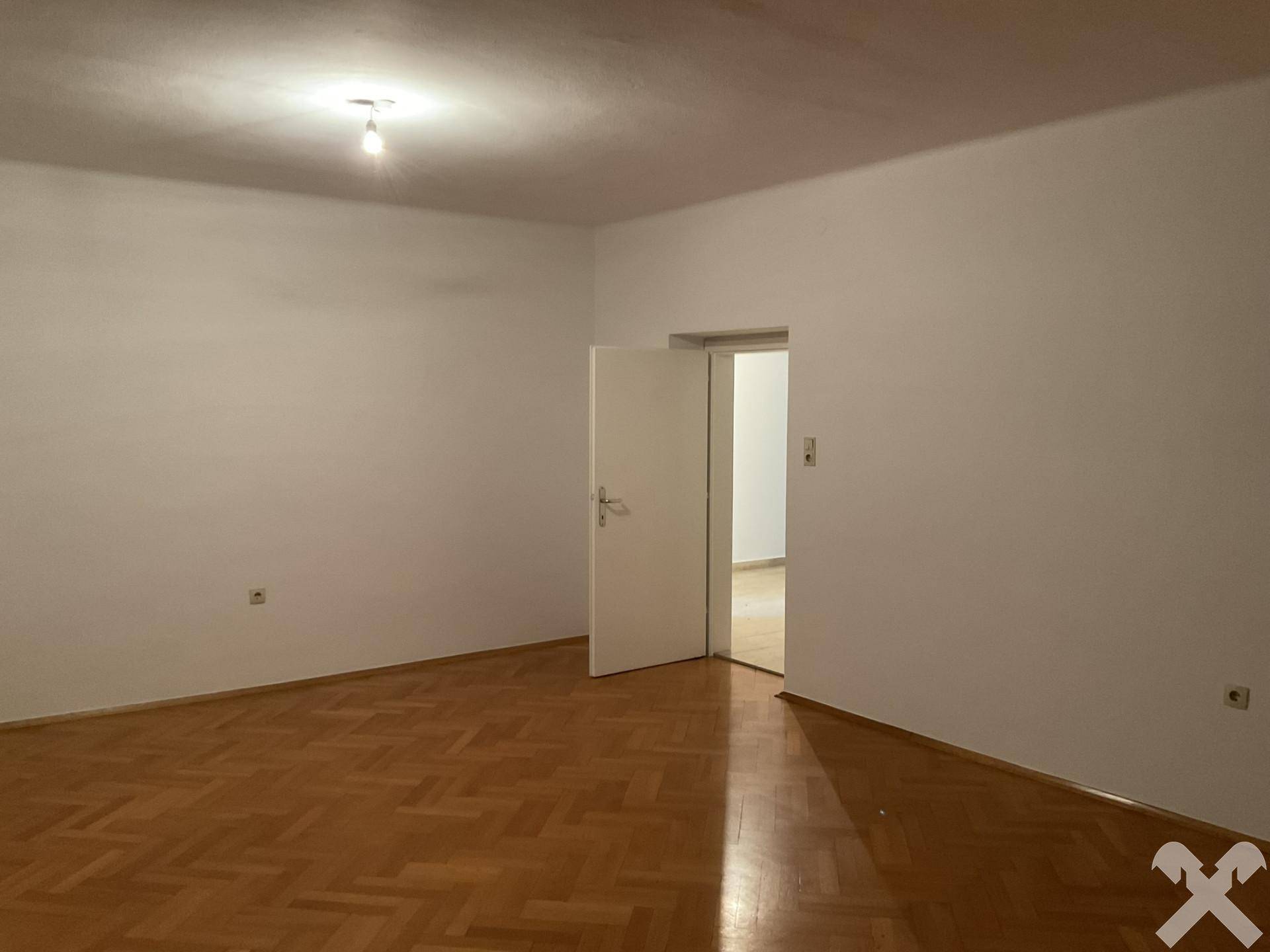 Schlafzimmer mit Parkettboden und weiß gestrichenen Wänden, bereit zur Einrichtung.