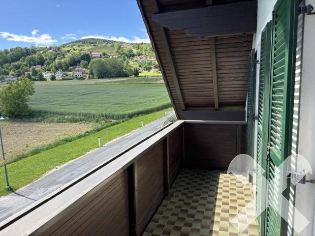 Geräumiger Balkon mit Fliesenboden und weitem Blick über die umliegende Landschaft.