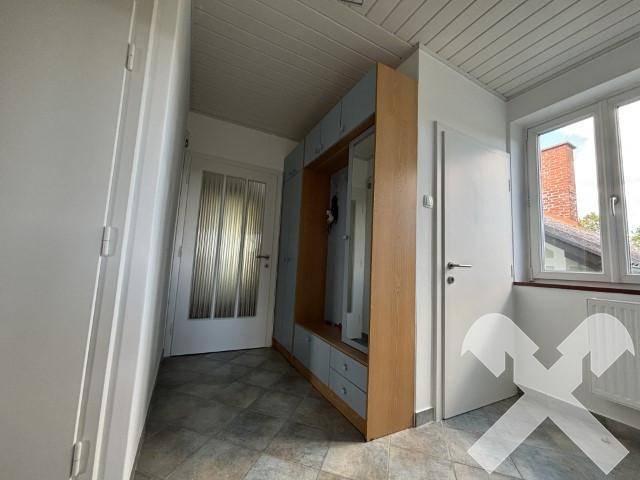 Heller Flur mit Fliesenboden, Einbauschrank und Zugang zu weiteren Räumen.