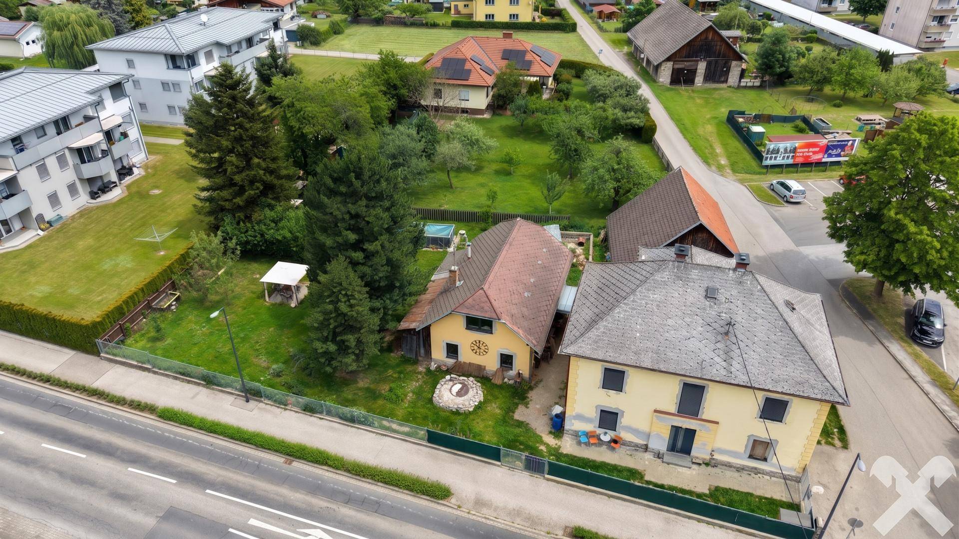 Luftaufnahme des Anwesens mit zwei Häusern, Garten und umliegender Wohnbebauung.