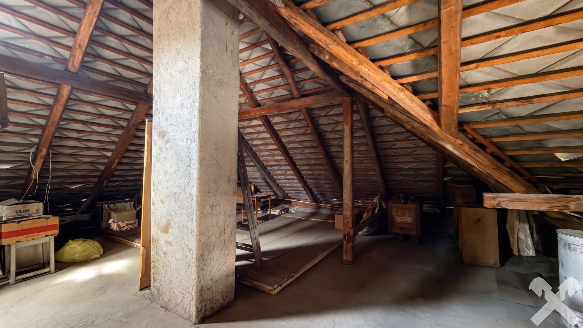 Unausgebauter Dachboden mit sichtbaren Holzbalken und viel Stauraum.