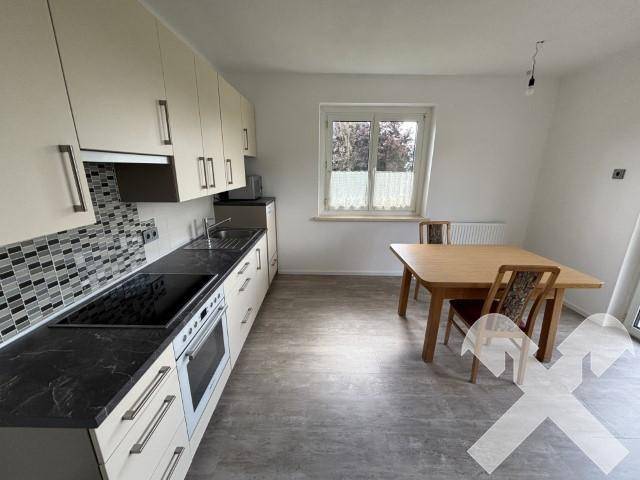 Geräumige Wohnküche mit Esstisch, Fenster und moderner Küchenzeile.