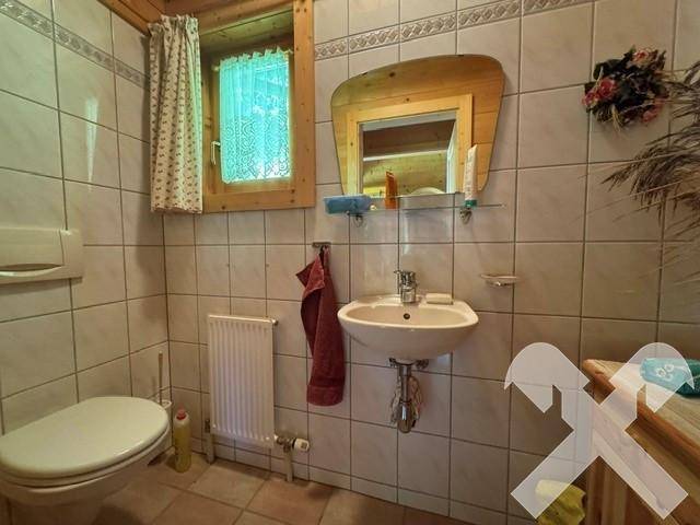 Kleines Gäste-WC mit Waschbecken, Toilette und Fenster für Belüftung.