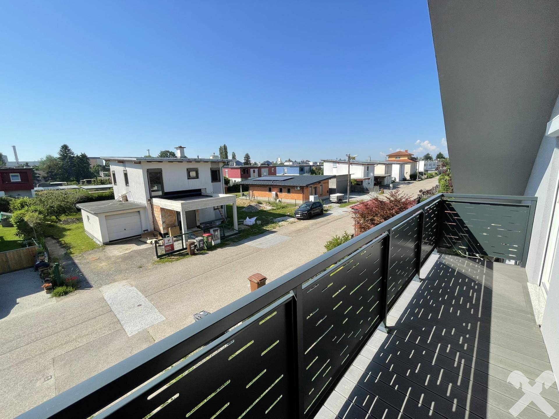 Balkon mit modernem Geländer und weitem Blick über die umliegende Wohngegend.