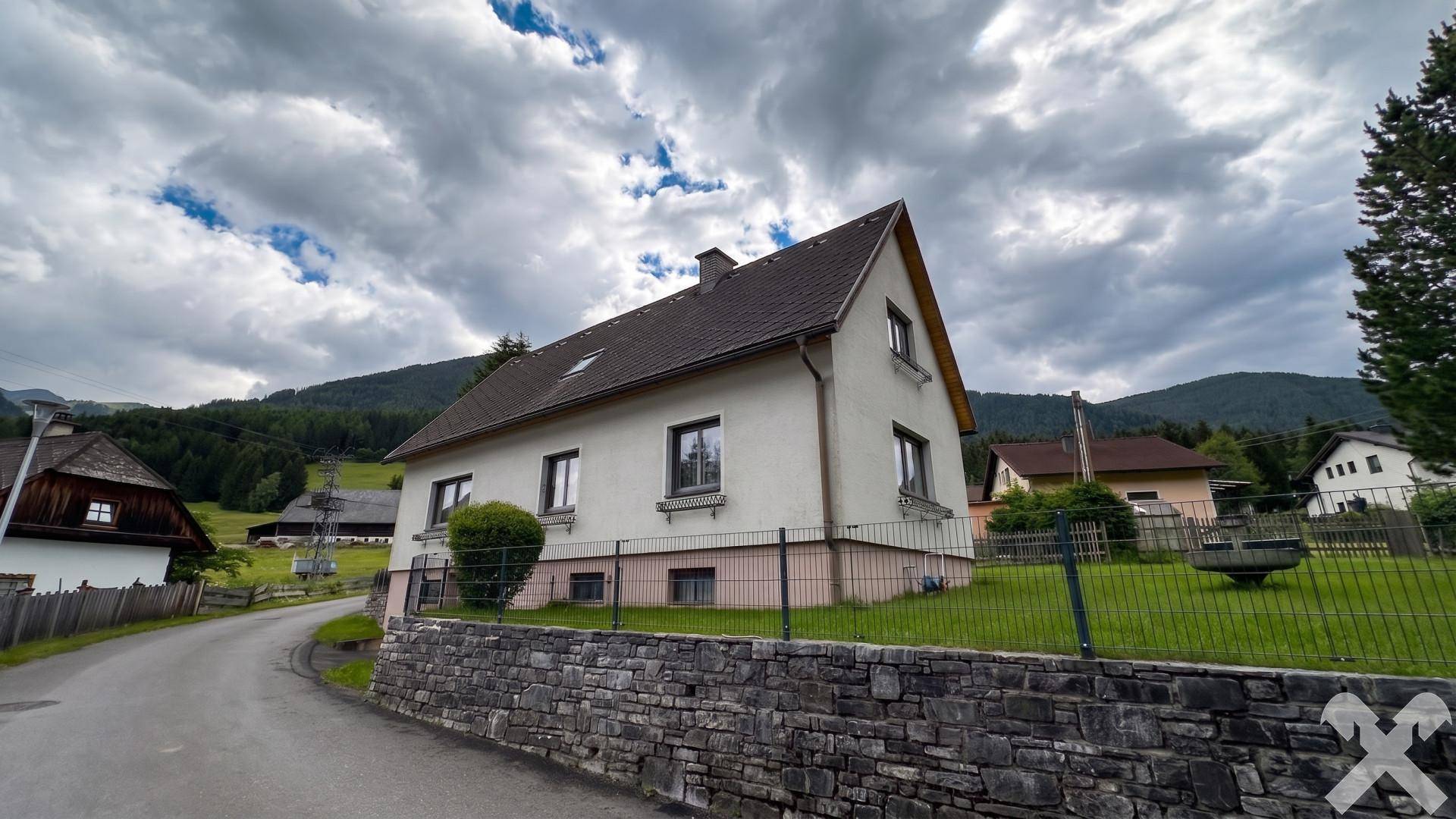 Blick auf das Haus von der Straße mit gepflegtem Vorgarten und traditioneller Architektur.