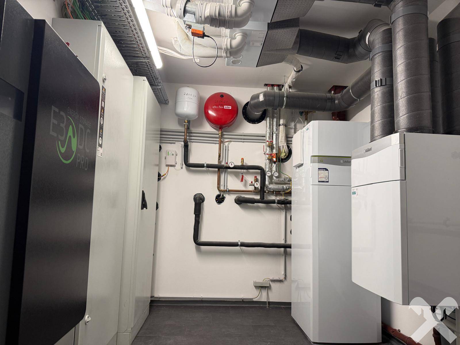 Technikraum mit moderner Heizungsanlage, Rohren und Energie-Speichersystem.