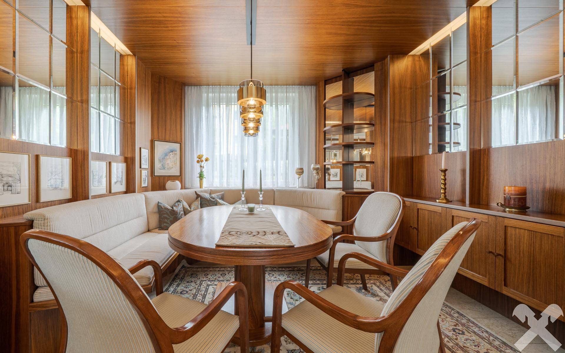 Exklusiver Essbereich mit Holztäfelung, integrierter Sitzbank und elegantem ovalen Esstisch.