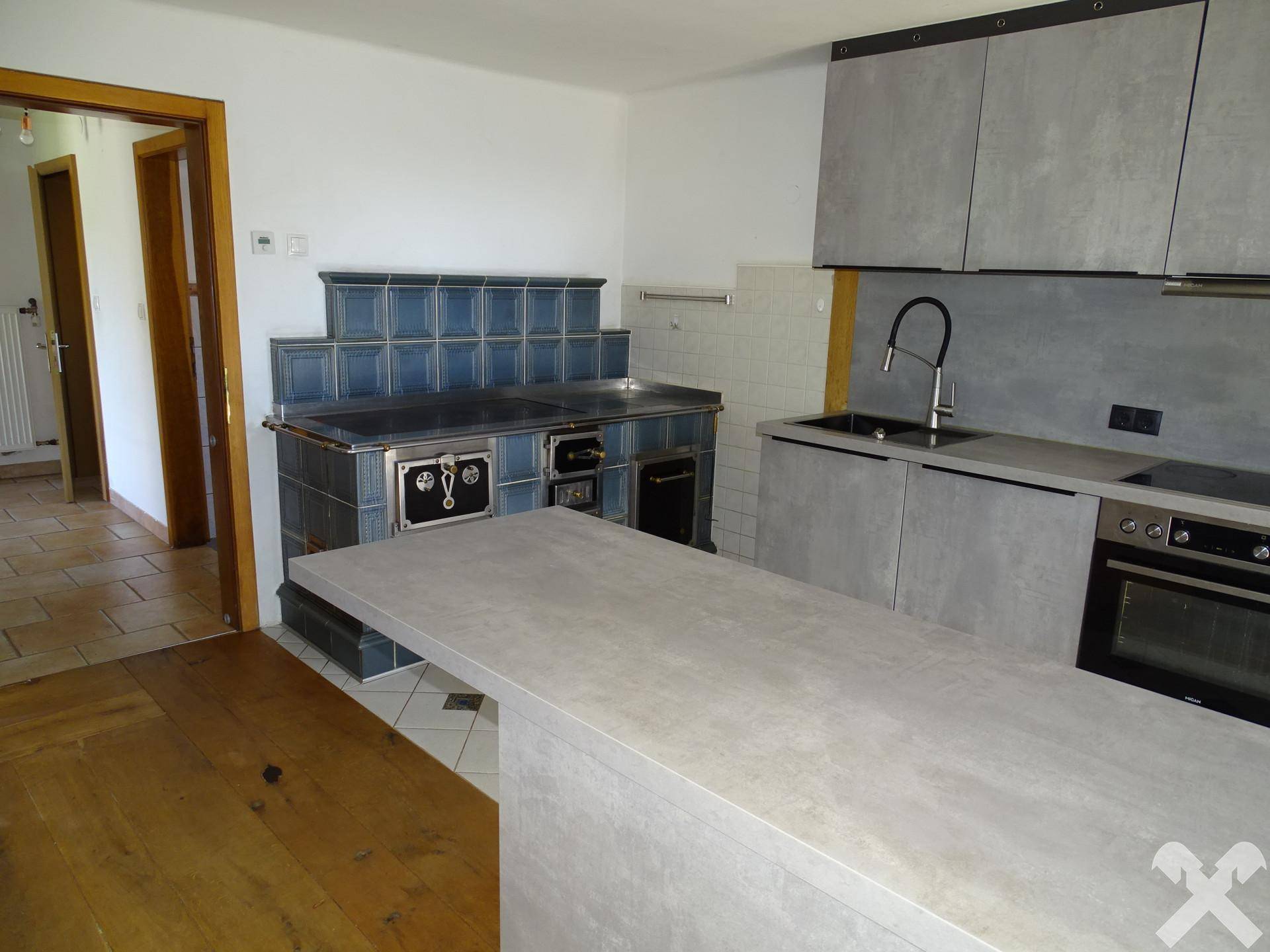 Geräumige Küche mit moderner Einrichtung, integriertem Backofen und einem blauen Kachelofen.