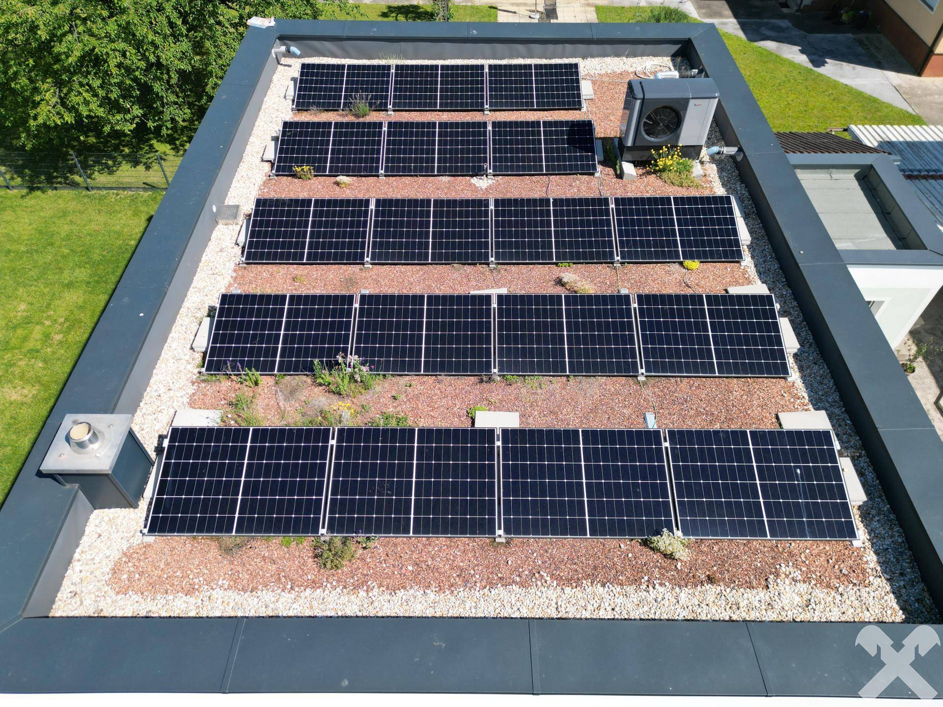 Nahaufnahme der Photovoltaikanlage auf dem begrünten Flachdach des modernen Wohnhauses.