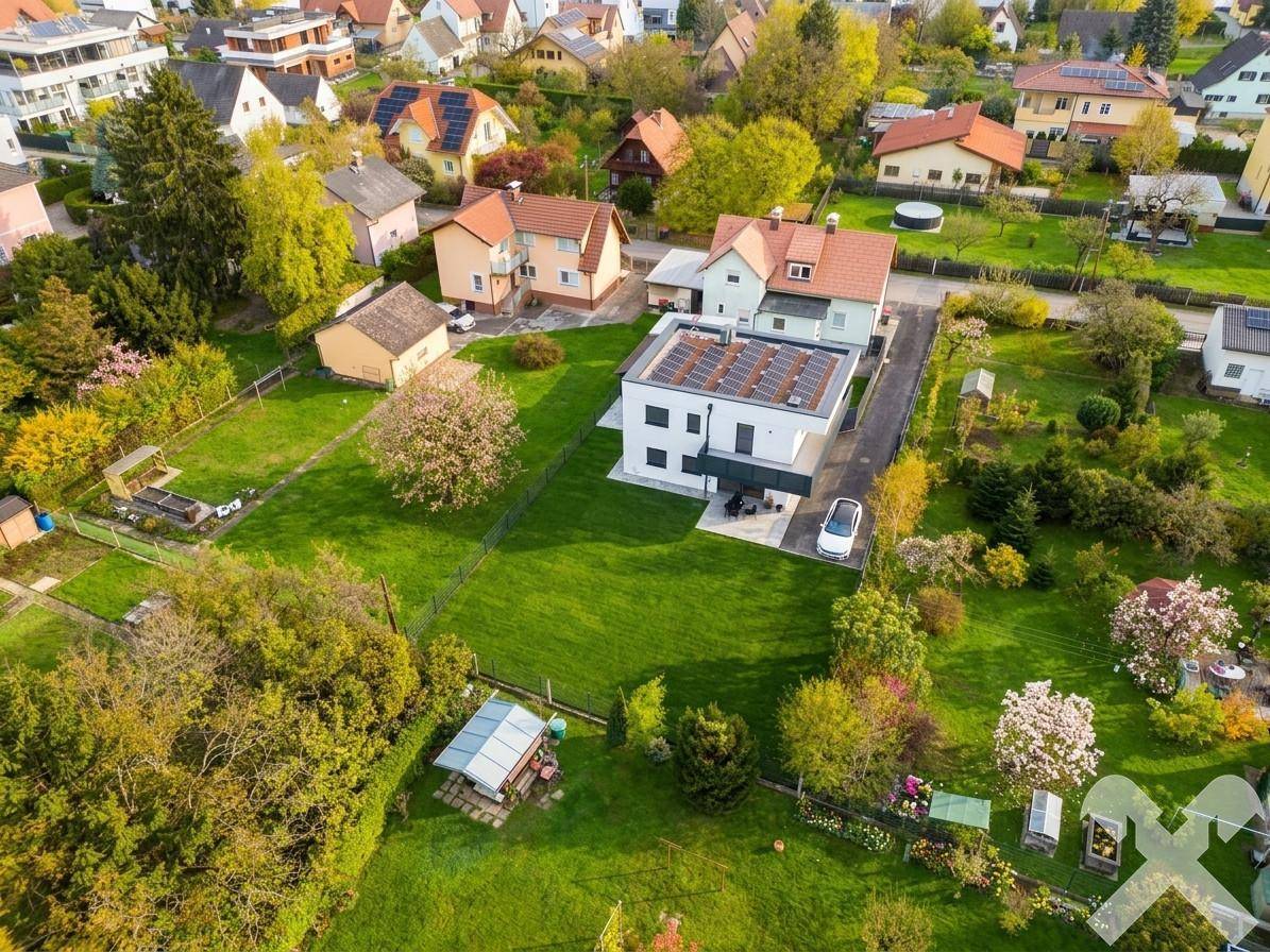 Weitläufige Luftaufnahme des Anwesens mit großem Garten und umliegender Wohnbebauung.