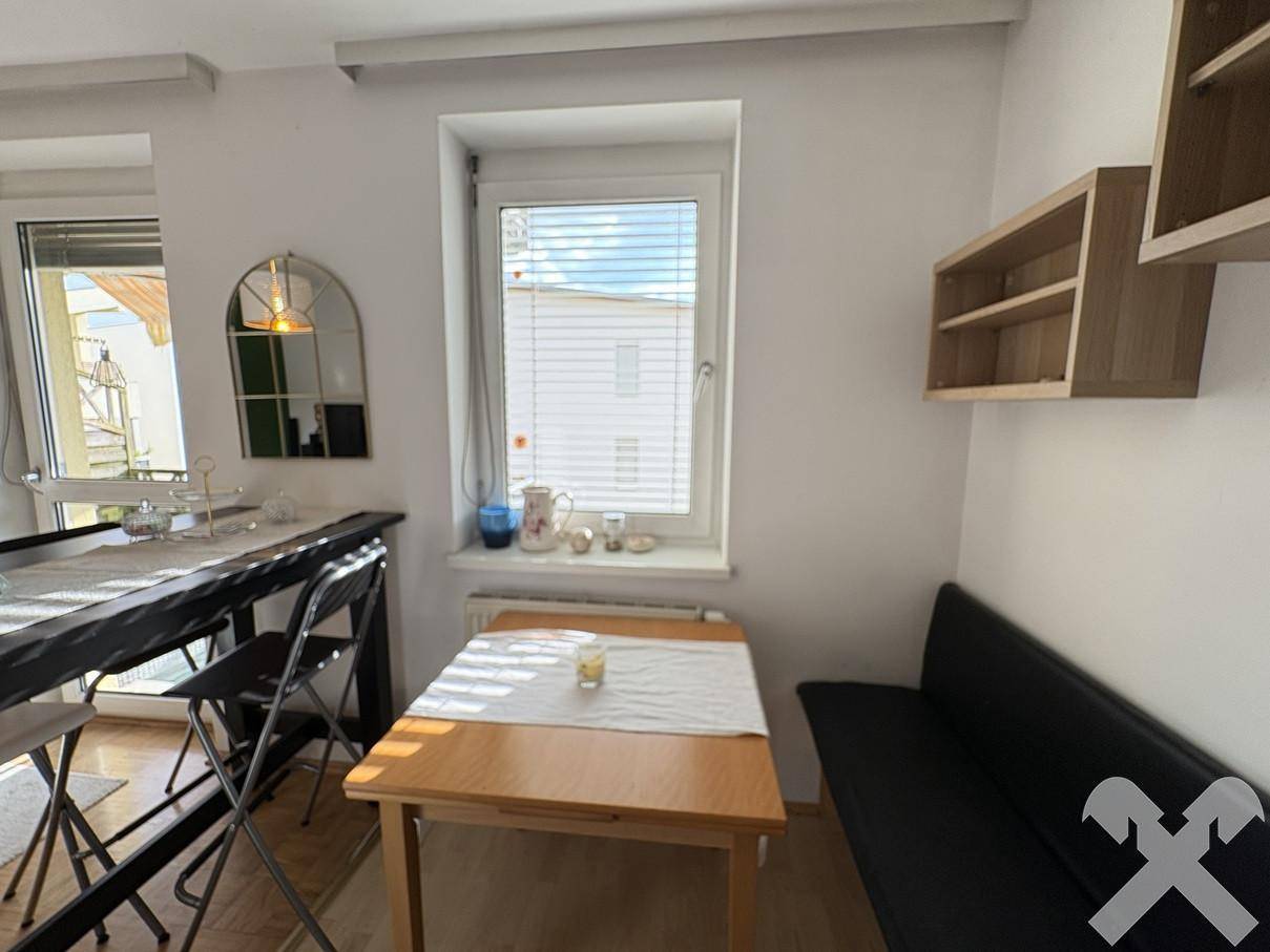Heller Essbereich mit Holztisch, Fenster und einer kleinen Sitzbank, ideal für Mahlzeiten.