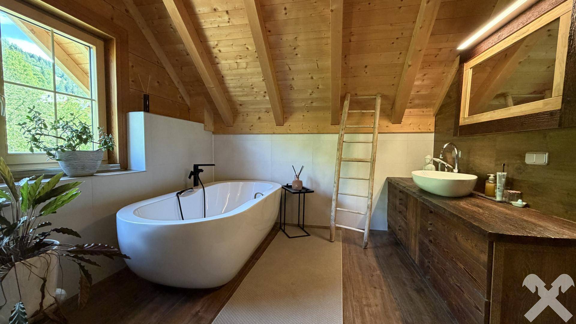 Modernes Badezimmer mit freistehender Badewanne, Holzwaschtisch und Holzdachschrägen.