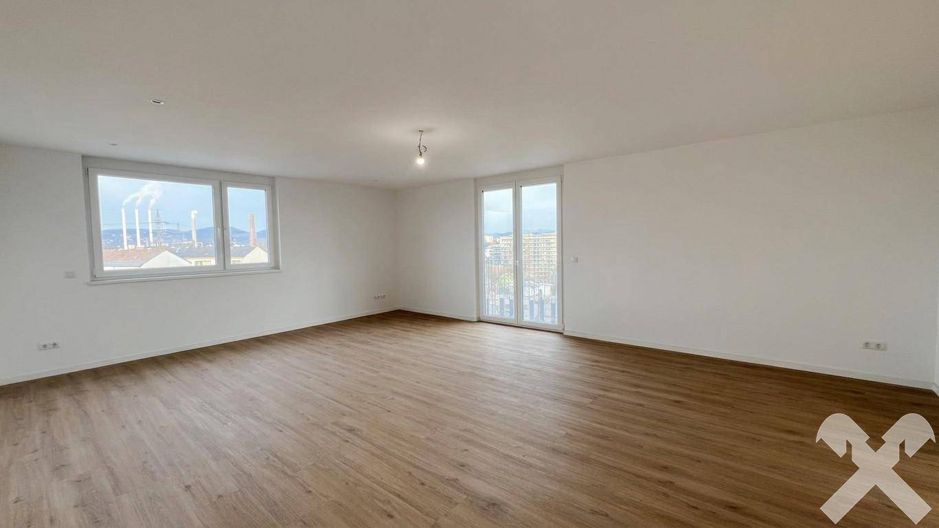 Geräumiger Wohnbereich mit Laminatboden, weißen Wänden und weitem Blick über die Stadt.