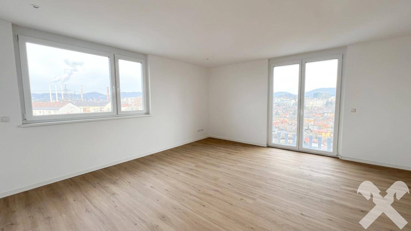 Heller Wohnraum mit Laminatboden, weißen Wänden und Panoramafenstern mit Stadtblick.
