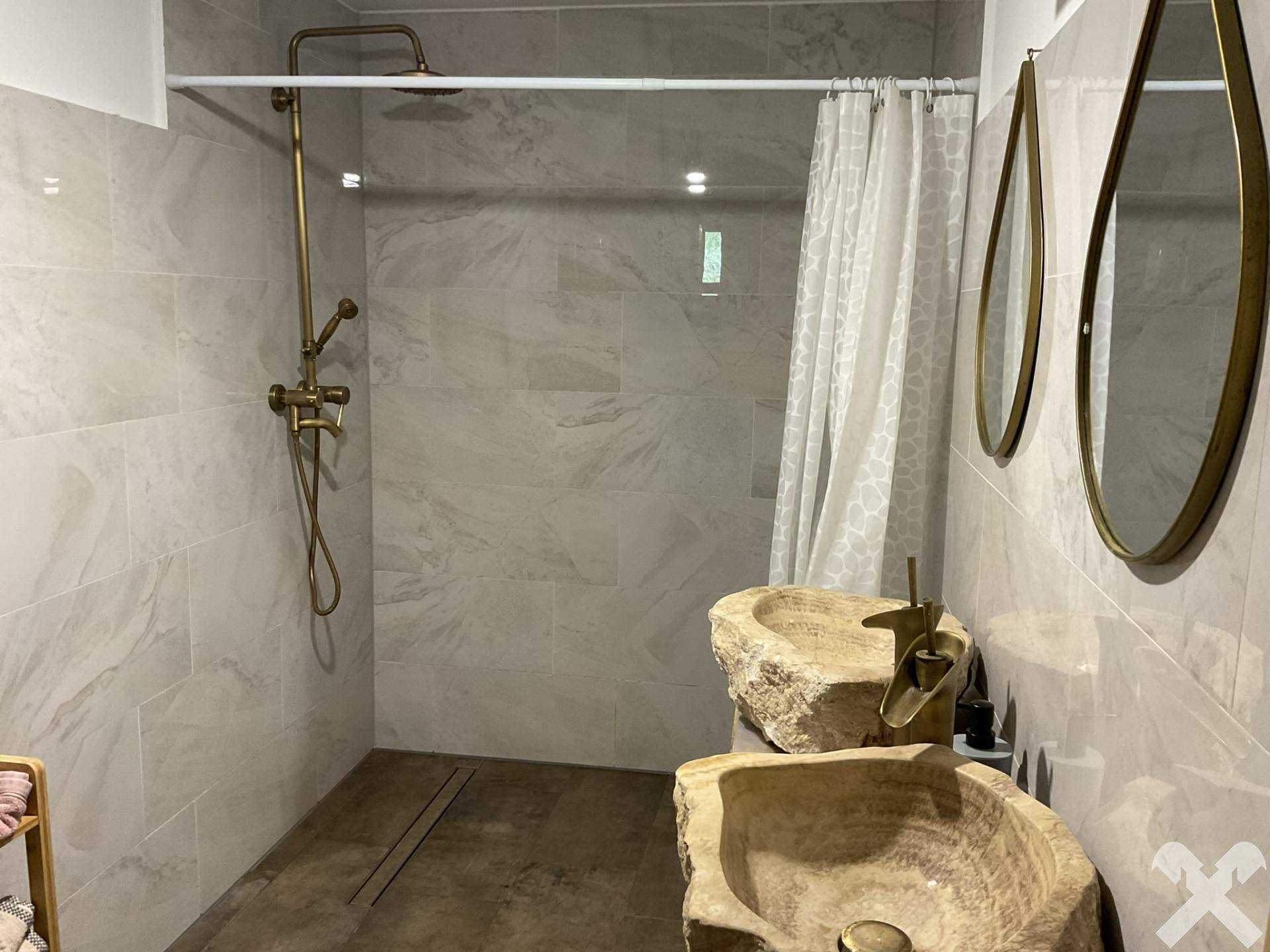 Modernes Badezimmer mit begehbarer Dusche und zwei einzigartigen Steinwaschbecken.