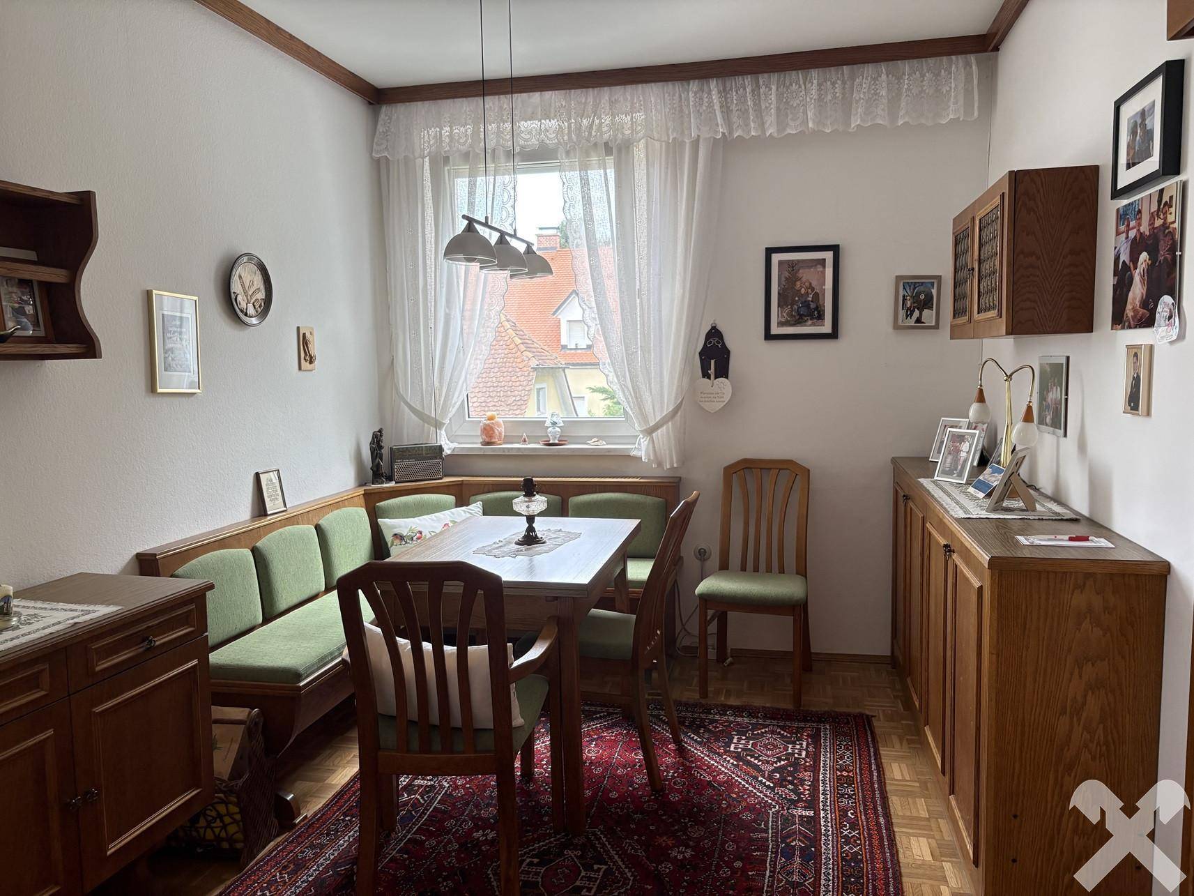 Esszimmer mit traditioneller Eckbank, Holztisch und Blick auf die Nachbarschaft.