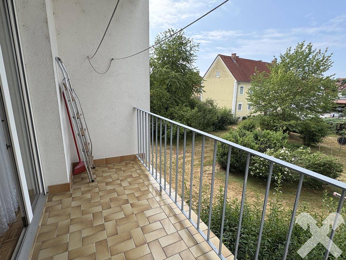 Schmaler Balkon mit Fliesenboden und einfacher Metallbrüstung, ideal für frische Luft.