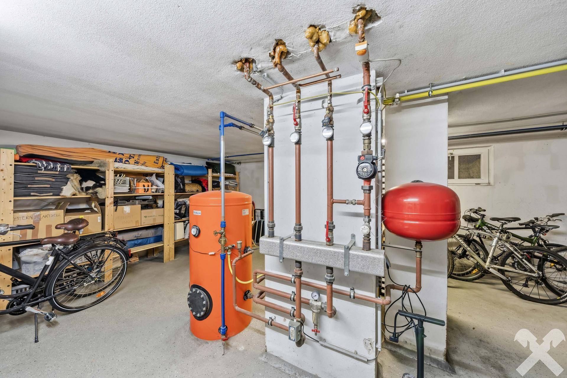 Technikraum im Keller mit Heizungsanlage, Warmwasserspeicher und Fahrradabstellmöglichkeiten.