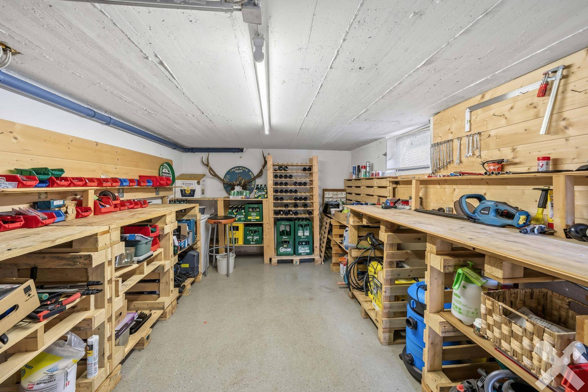 Geräumiger Hobbyraum im Keller mit Werkbänken, Regalen und viel Stauraum.