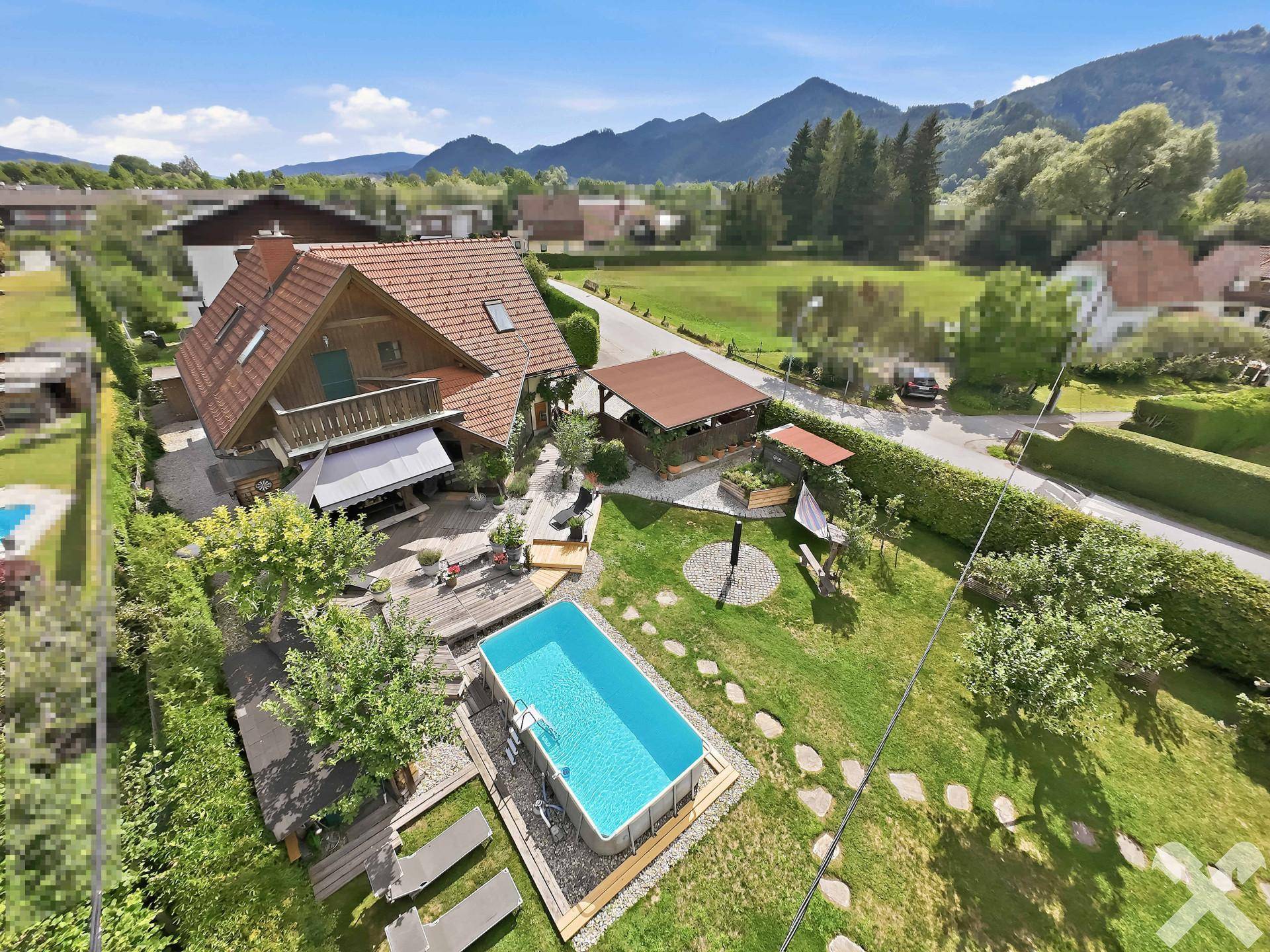Übersicht aus der Luft auf das Wohnhaus mit großer Terrasse, Pool und gepflegtem Gartenbereich.