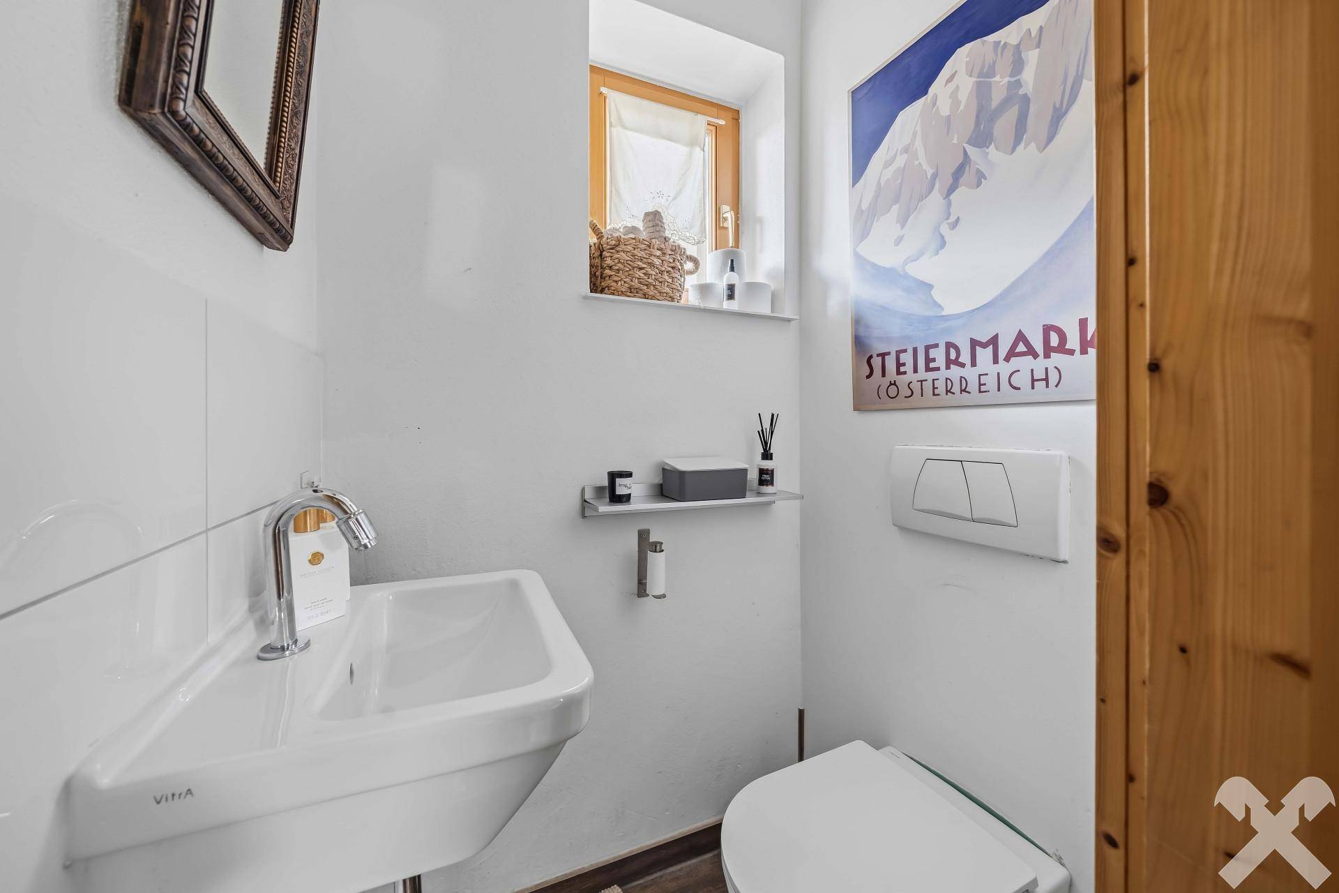 Kleines Gäste-WC mit modernem Waschbecken, wandhängendem WC und einem Fenster für Tageslicht.