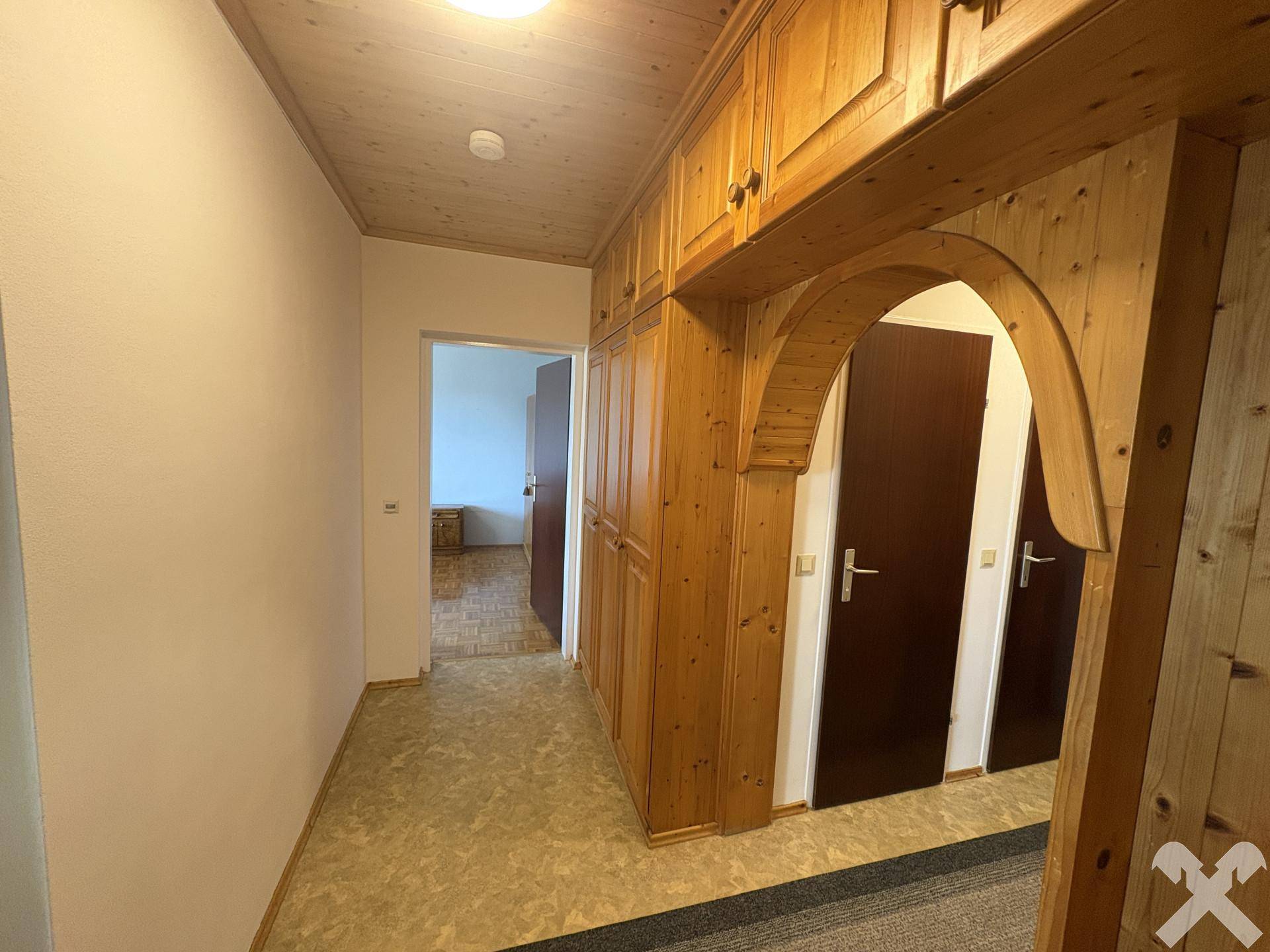 Geräumiger Flur mit Holzdecken, Einbauschränken und Zugang zu weiteren Räumen, gut erhalten.