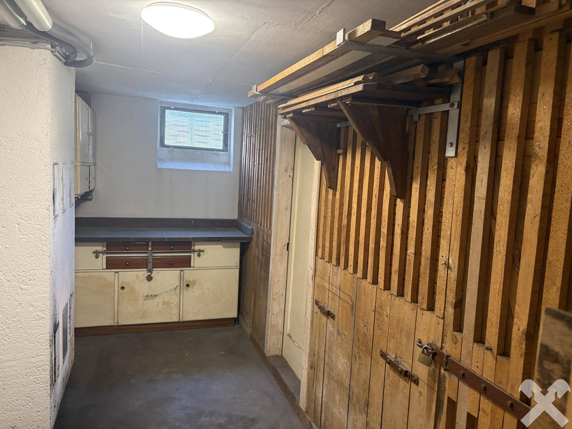 Kellerraum mit Holzregalen, einem alten Schrank und einem kleinen Fenster, bietet viel Stauraum.